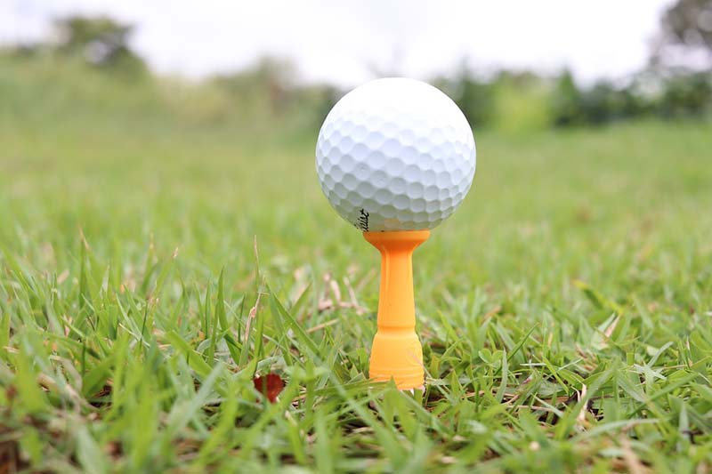 Người chơi đặt bóng golf của mình lên một giá đỡ nhỏ